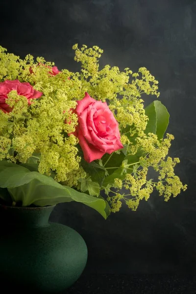 暗い背景を背景に丸い花瓶にピンクのバラの花の配置 — ストック写真