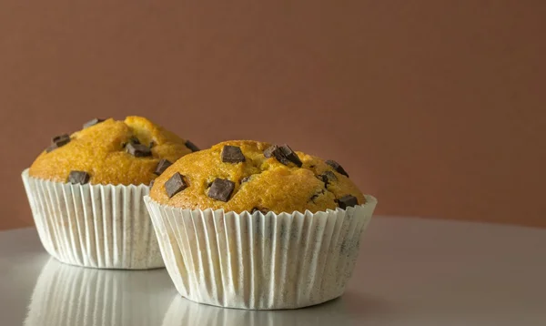 Muffin con gocce di cioccolato su sfondo marrone — Foto Stock