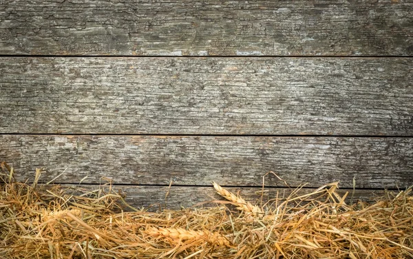 Straw and wheat on a rustic wooden background — Stock Photo, Image