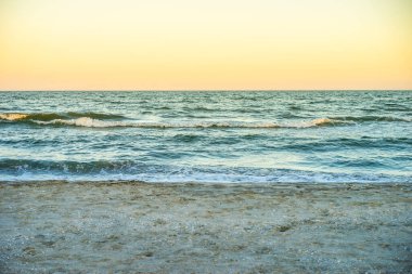 Gün batımında turuncu gökyüzü ile deniz kenarında alacakaranlık