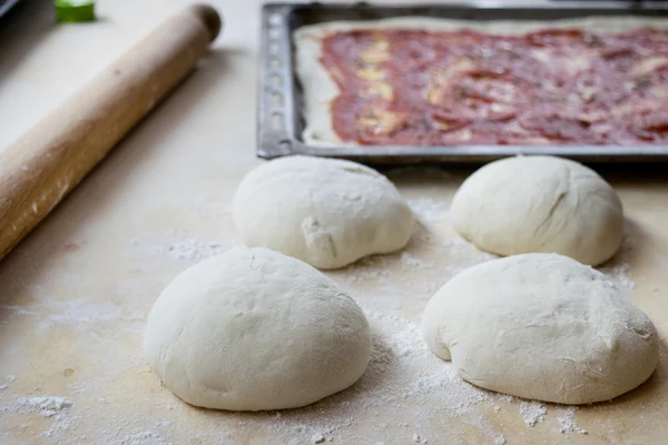 pastry board rolling pin and dough balls to make the pizza