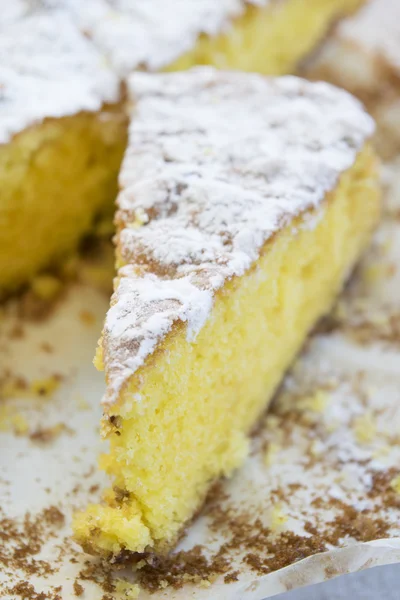 Stukje spons cake met poedersuiker — Stockfoto