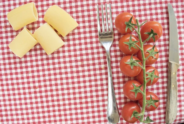 Plat leggen van paccheri cherry tomaten en parmezaanschilfers tussen cutler — Stockfoto