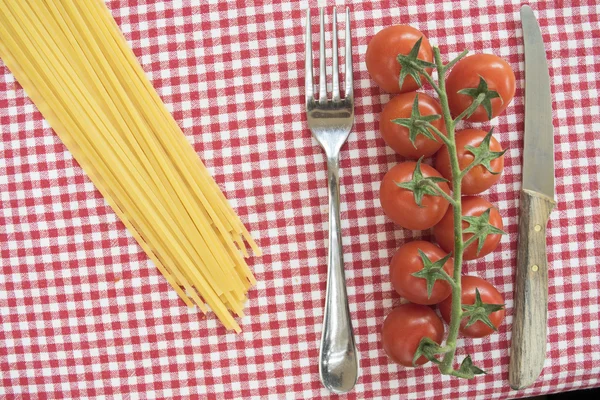 Leigos planos de espaguete tomates cereja e parmesão entre cutle — Fotografia de Stock