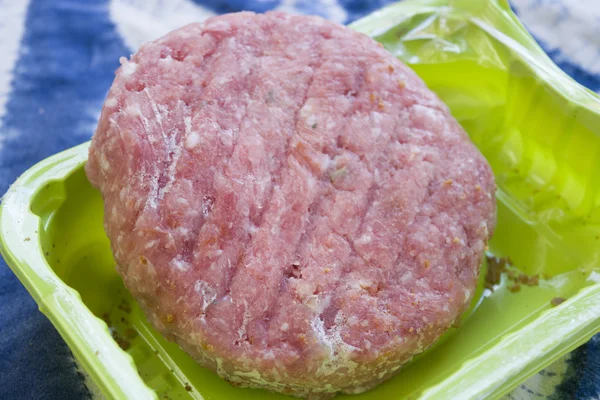 Hambúrguer congelado em uma banheira de plástico — Fotografia de Stock