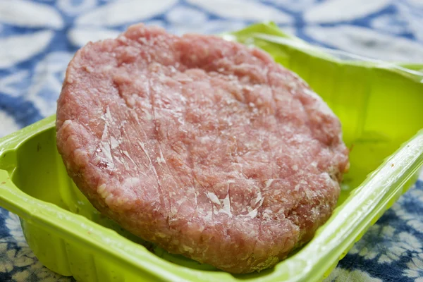 Hambúrguer congelado em uma banheira de plástico — Fotografia de Stock