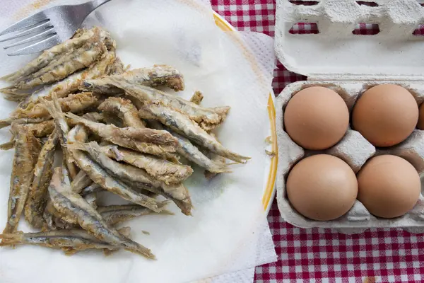 Puesta plana de anchoas fritas con huevos frescos —  Fotos de Stock