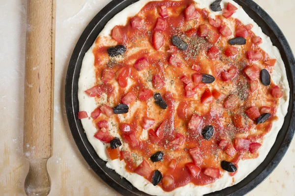 Tendido plano de pizza con tomate fresco y rodillo — Foto de Stock