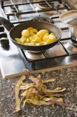 Yeni patates ön planda kabukları ile tavada kızartma