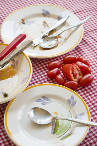 Verse tomaten op een tabel met vuile platen — Stockfoto