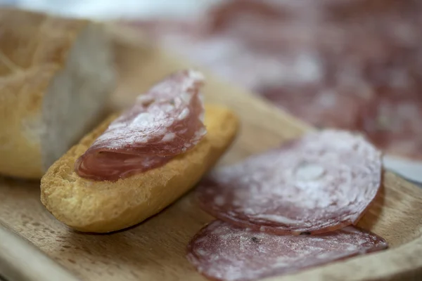 Delicatessen with toast and salami — Stock Photo, Image