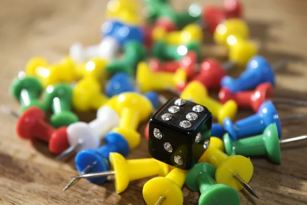 Die and colored pushpins — Stock Photo, Image