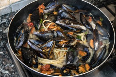 Taze midyeli linguine deniz ürünleri makarnası tavada buharı, ev yapımı Akdeniz konforlu gıdası, ocakta kırsal İtalyan aile yemeği.