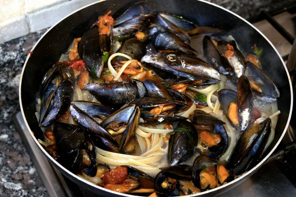 Taze midyeli linguine deniz ürünleri makarnası tavada buharı, ev yapımı Akdeniz konforlu gıdası, ocakta kırsal İtalyan aile yemeği.