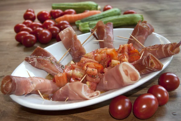 Aperitivo no presunto cru e tomates — Fotografia de Stock