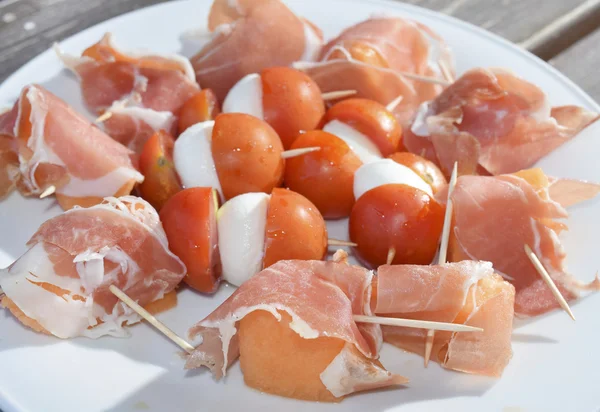 Canapes pácolt sonka dinnye koktélparadicsommal és mozzarellával — Stock Fotó