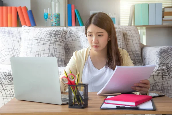 Young woman working on laptop at home, female using laptop computer.Asian business girl with online meeting in video conference call. People working from home.Self quarantine, work from home, covid-19 coronavirus, social distance concept.