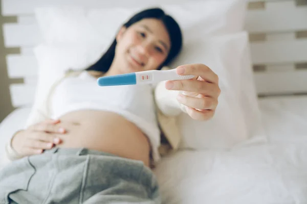 Happy Wanita Berbaring Tempat Tidur Menunjukkan Tes Kehamilan Tongkat Home Stok Foto