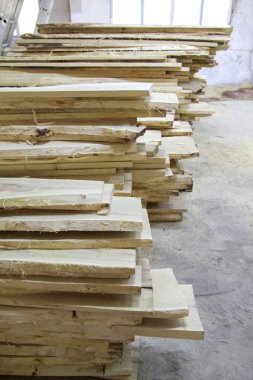 Dikey çerçevede bir yığın pürüzlü tahta. İnşaat ve ahşap işçiliği için kereste deposu. Atölye, endüstri, doku.