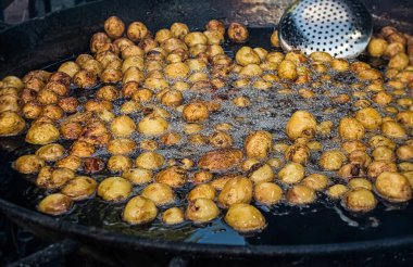 Açık hava patatesi büyük dökme demir tavada pişiyor..