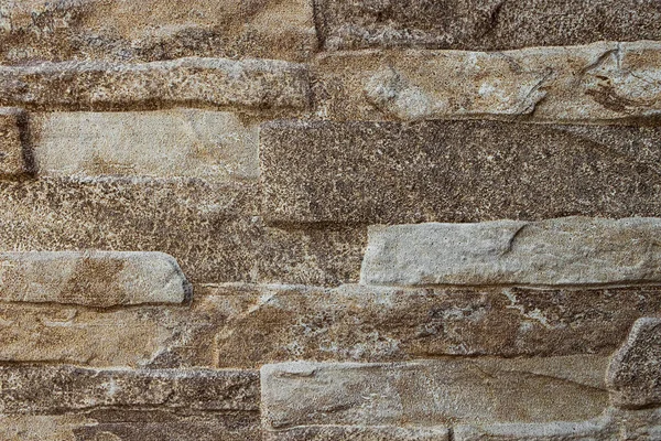 Beige melange porous stone texture with bricks.