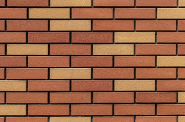 Kahverengi ve sarı mozaik tuğla duvar.