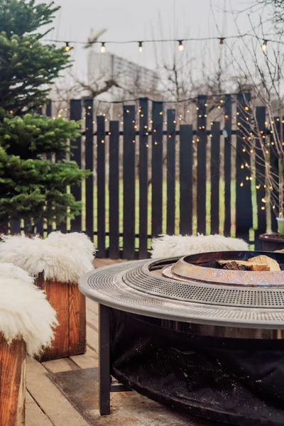 Sıcak bir terasta yanan odunları olan açık hava ateş çukuruna.