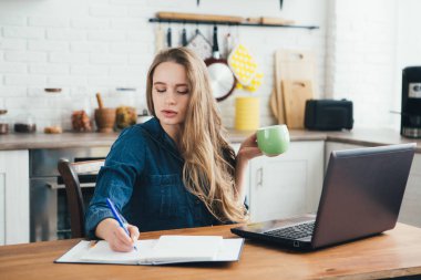 Genç ve güzel hamile bir kız. Karantinada kendini soyutlama modunda mutfakta çalışan bir serbest çalışan. Tonlama.