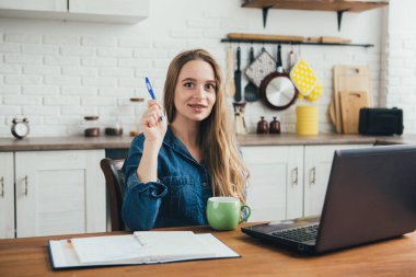 Genç ve güzel hamile bir kız. Karantinada kendini soyutlama modunda mutfakta çalışan bir serbest çalışan. Tonlama.