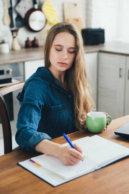 Genç ve güzel hamile bir kız. Karantinada kendini soyutlama modunda mutfakta çalışan bir serbest çalışan. Tonlama.