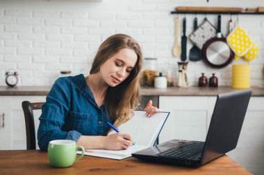 Genç ve güzel hamile bir kız. Karantinada kendini soyutlama modunda mutfakta çalışan bir serbest çalışan. Tonlama.