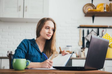 Genç ve güzel hamile bir kız. Karantinada kendini soyutlama modunda mutfakta çalışan bir serbest çalışan. Tonlama.