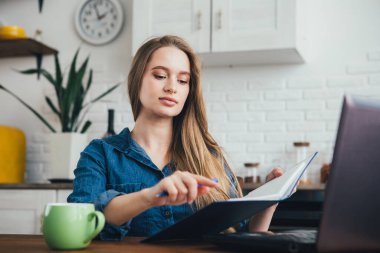 Genç ve güzel hamile bir kız. Karantinada kendini soyutlama modunda mutfakta çalışan bir serbest çalışan. Tonlama.