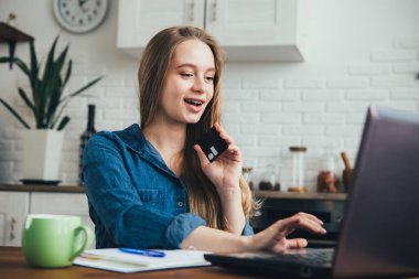 Genç ve güzel hamile bir kız karantinada kendini izole etme modunda çalışıyor ve online alışverişler yapıyor. Tonlama.