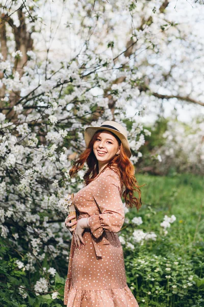 Young Beautiful Red Haired Girl Walks Spring Blooming Apple Orchard Royalty Free Stock Images