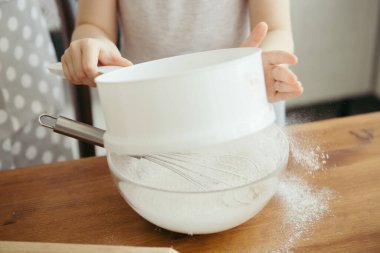 Sevimli küçük kız, annenin mutfakta kurabiye pişirmesine yardım ediyor. Mutlu bir aile. Tonlama.