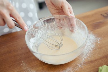 Genç ve güzel bir kadın mutfakta kurabiye pişirmek için hamur yoğurur. Tonlama.