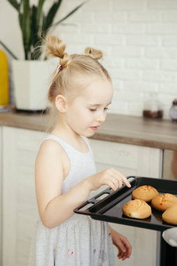 Sevimli küçük kız, annenin mutfakta kurabiye pişirmesine yardım ediyor. Mutlu bir aile. Tonlama.