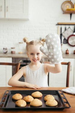 Mutfakta taze pişmiş kurabiye yiyen tatlı küçük kız. Mutlu bir aile. Tonlama.