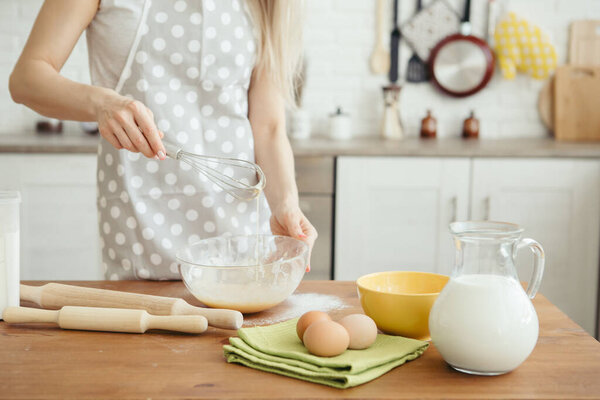 молодая красивая женщина разминает тесто для выпечки печенья на кухне. тонирование.