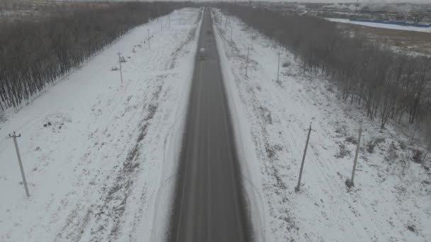 Voitures rouler par la route parmi les arbres enneigés pendant — Video