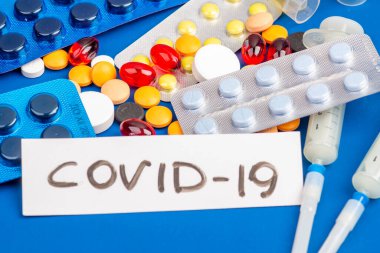 Covid-19, tıbbi aletler, şırınga ve renkli ilaçlar.