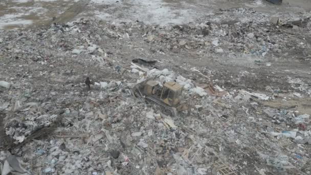 Buldozer traktor mendorong sampah dari gunung di dump kota — Stok Video