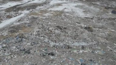 Buldozer traktörü şehir çöplüğündeki bir dağdan çöp atıyor.