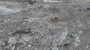 Buldozer traktörü şehir çöplüğündeki bir dağdan çöp atıyor.