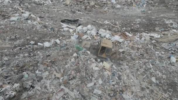 Бульдозерный трактор толкает мусор с горы на городской свалке — стоковое видео