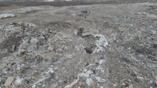 Bulldozer trekker duwt afval van een berg in een stad dump — Stockvideo