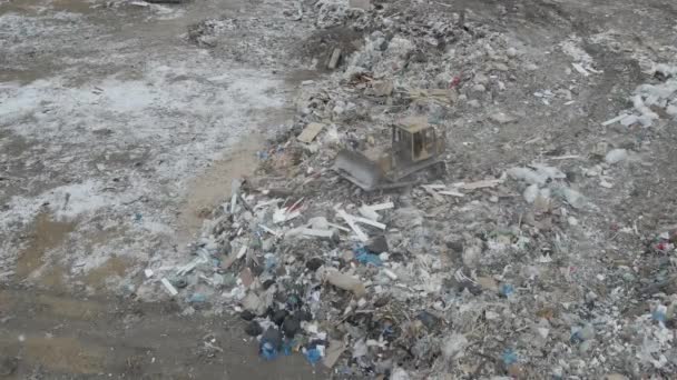 Trator bulldozer empurra lixo de uma montanha em uma lixeira da cidade — Vídeo de Stock