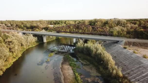 Strzał drona lotniczego starego zardzewiałego żelaza nieużywany most kolejowy nad rzeką. — Wideo stockowe