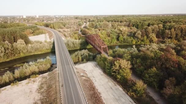 Strzał drona lotniczego starego zardzewiałego żelaza nieużywany most kolejowy nad rzeką. — Wideo stockowe